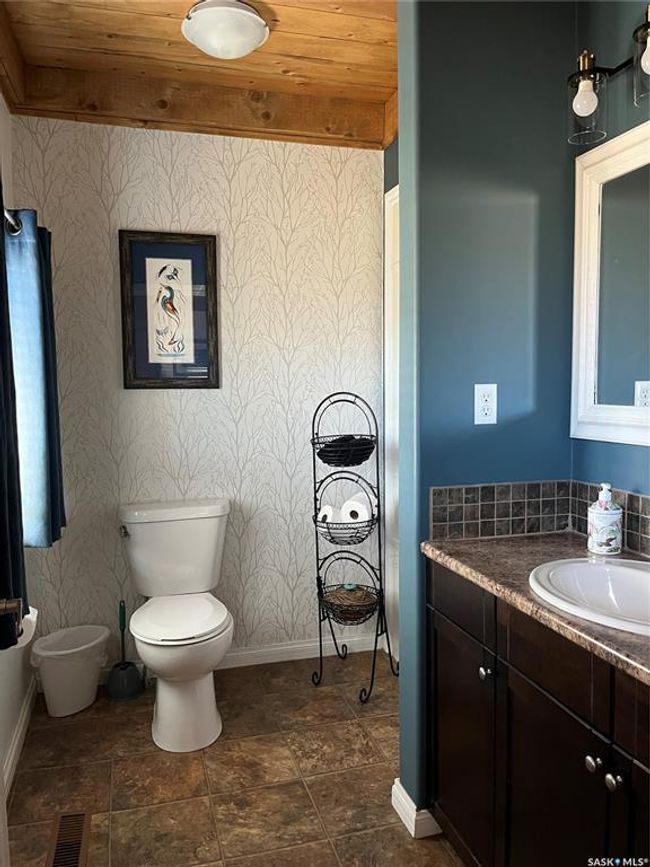 Bathroom featuring visible vents, wallpapered walls, baseboards, wooden ceiling, and toilet | Image 26