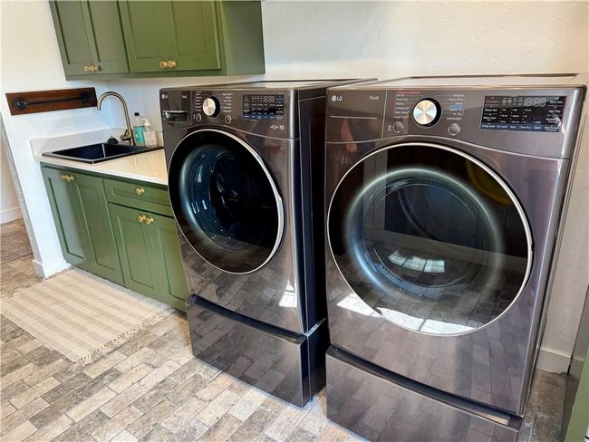 Laundry area with washer and clothes dryer, cabinet space and wash extra large sink. | Image 23