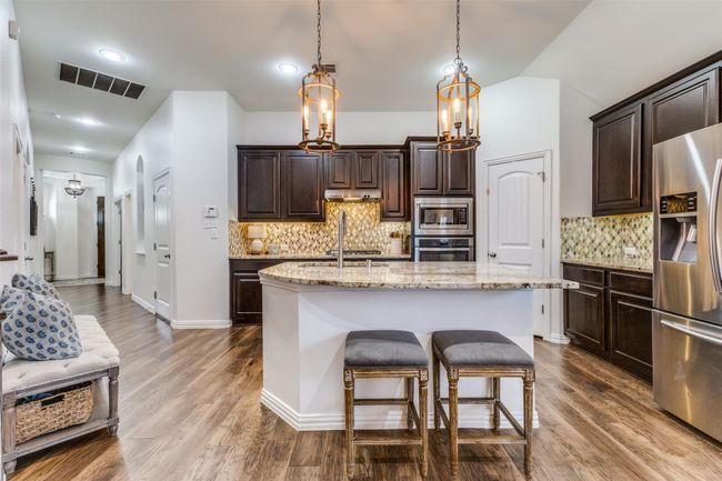 Looking back into the kitchen notice the under-cabinet lighting and breakfast bar. | Image 14