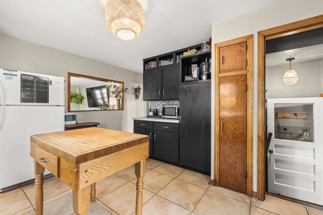 View in kitchen to living room. There is an interior window opening from kitchen to living room. | Image 8