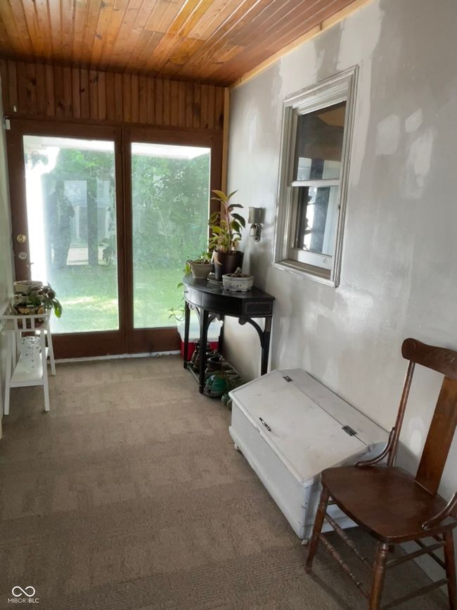 living area with wood ceiling and carpet flooring | Image 17
