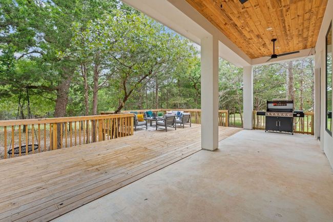 Covered back patio with extended wooden deck with grilling area and an outdoor living space | Image 35