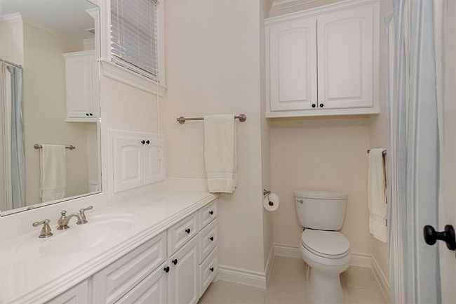 The bathrooms in this home are neutral and have plenty of cabinet storage | Image 34
