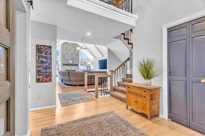 Entrance foyer featuring hardwood / wood-style flooring, high vaulted ceiling, and ceiling fan | Image 3