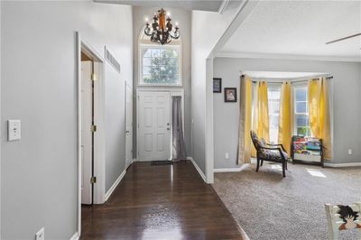 Entryway with a textured ceiling, dark wood-type flooring, ornamental molding, and a notable chandelier | Image 3