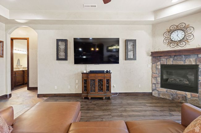 Living room with a fireplace, arched walkways, wood finished floors, and a raised ceiling | Image 40