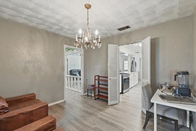 Dining room featuring light wood finished floors, a chandelier, and baseboards | Image 14