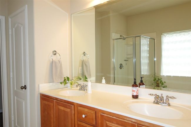 Full bathroom featuring a shower stall and double vanity | Image 17