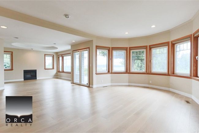 Unfurnished living room featuring a glass covered fireplace, light wood-style floors, and recessed lighting | Image 13
