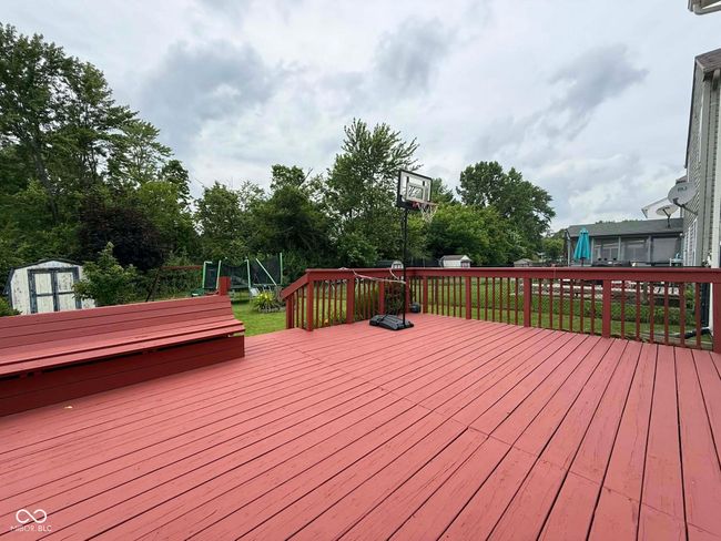 wooden terrace with a shed, view of scattered trees, and a yard | Image 10