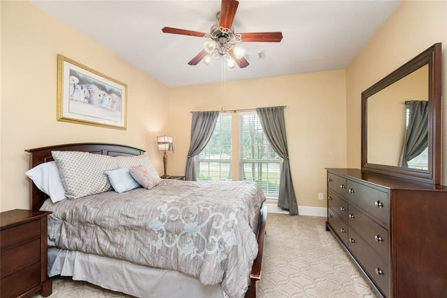 This spacious secondary bedroom offers plenty of room for everyone, featuring ample space for a king-size bed, desk, or play area. The thoughtful layout ensures comfort and flexibility for various uses. | Image 22