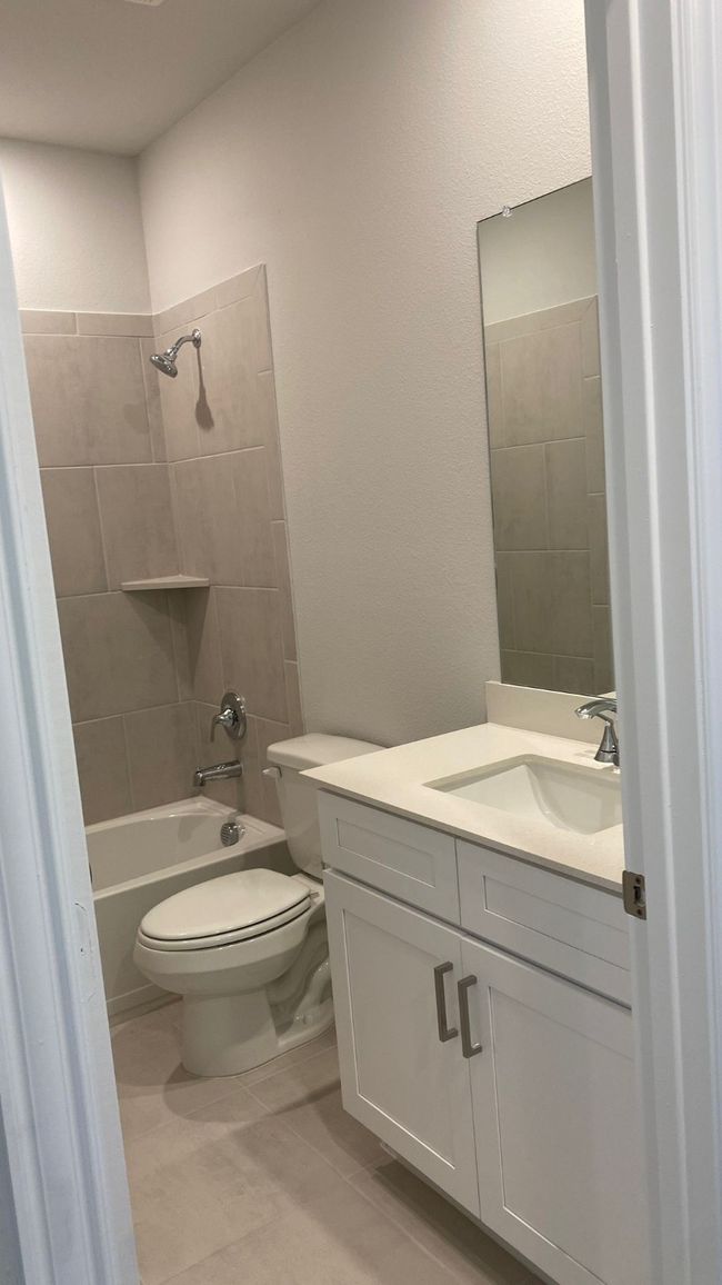 Bathroom featuring toilet, vanity, shower / tub combination, and tile patterned floors | Image 13