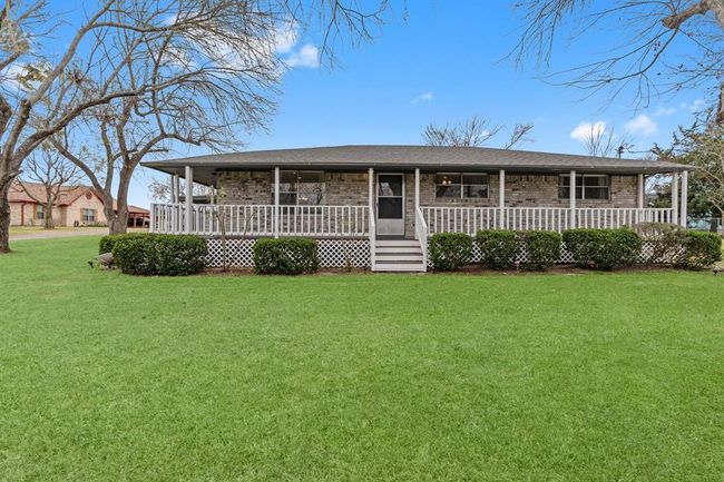 This charming home features a spacious front porch and a well-maintained lawn, offering a cozy and inviting curb appeal. | Image 4