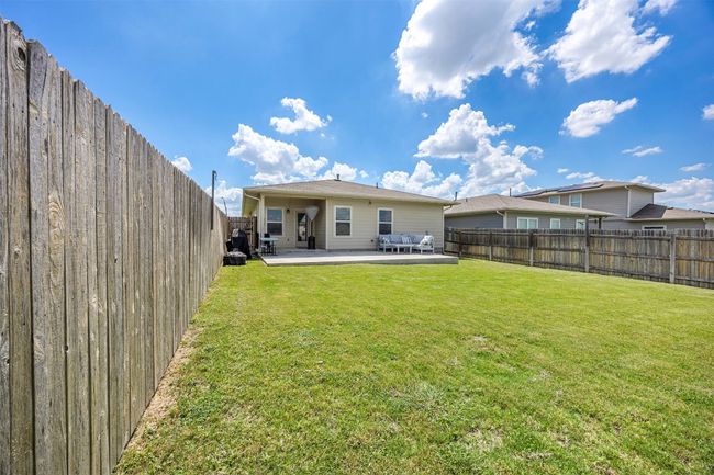 The fully fenced backyard, offering a private outdoor space for relaxation or play, complete with a generous lawn area. | Image 24