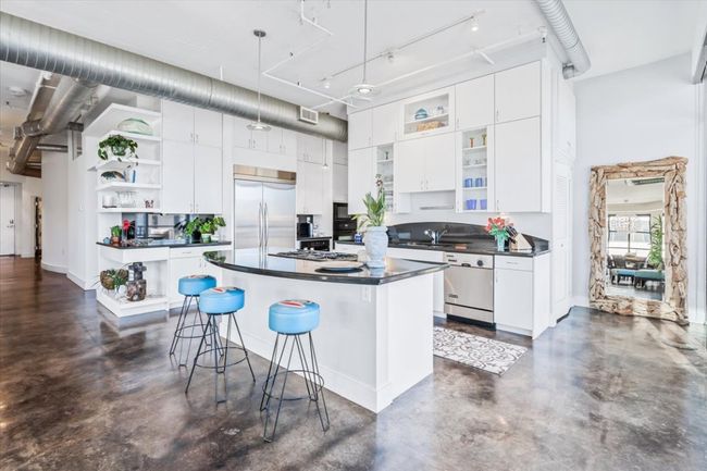 Kitchen with open shelves, Ink granite countertops, stained concrete floors, white cabinets, and a 11' high ceiling | Image 5