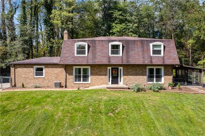 View of front facade with a sunroom, cooling unit, and a front lawn | Image 1