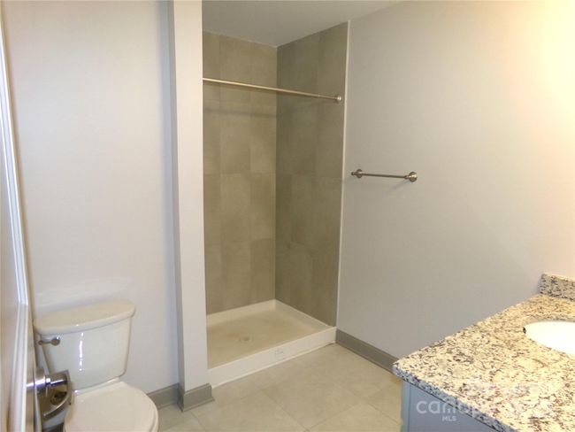 No tubs here enjoy a large shower and granite vanity top sink. | Image 10