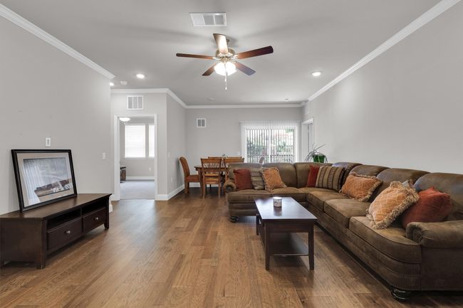 Living room featuring ceiling fan, recessed lighting, plenty of natural light, wood finished floors, and baseboards | Image 7
