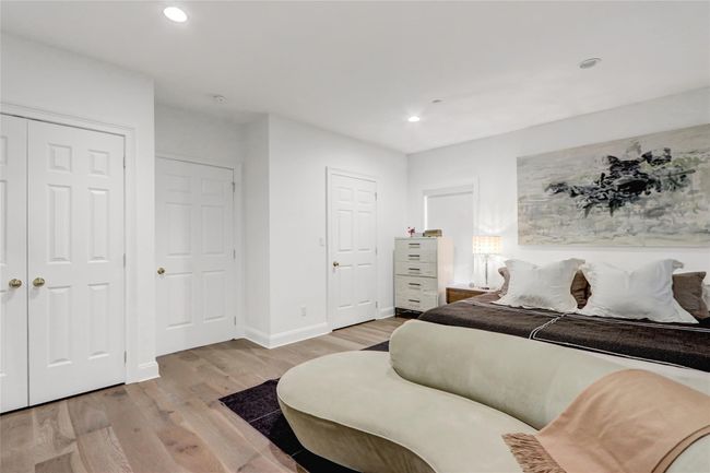 Bedroom with light wood finished floors, recessed lighting | Image 15