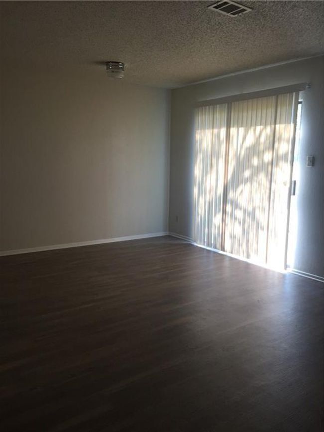 Unfurnished room with dark wood-style flooring, a textured ceiling, baseboards, and visible vents | Image 11