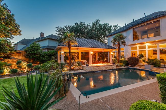 The back yard Impresses!, with a sparkling pool, spa, an elongated firepit, tile-roofed outdoor living space, koi pond, and green grassy area. You'll feel like you are at your favorite resort! | Image 30