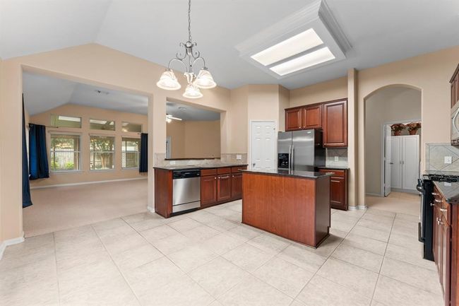 From the breakfast room, enjoy peaceful views of the backyard while natural light pours into the heart of the home. The open-concept layout connects the kitchen seamlessly to the family room, creating a spacious and inviting atmosphere ideal for everyday living and entertaining. | Image 12