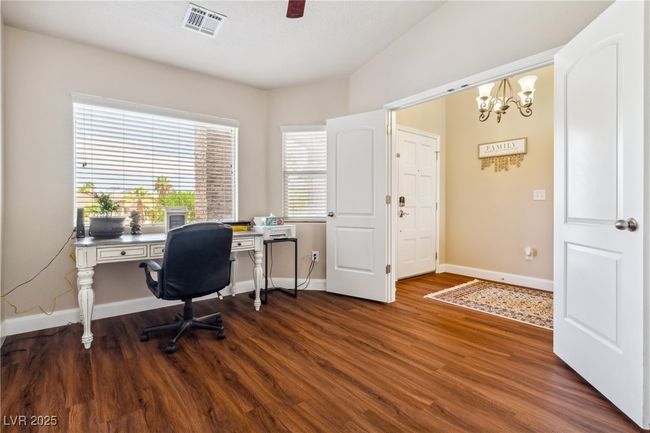 Office featuring dark wood-type flooring, a chandelier, and baseboards | Image 9