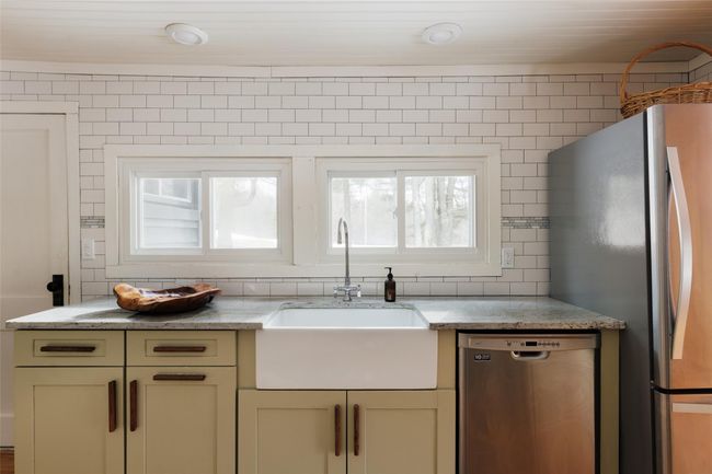 Kitchen with sink, stainless steel appliances, tasteful backsplash, light stone countertops, and cream cabinetry | Image 18