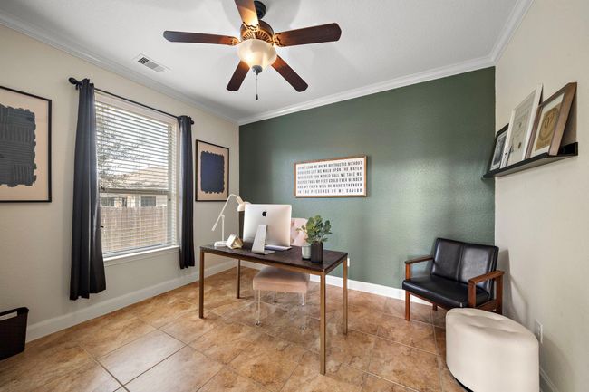 Offering ample natural light, this dedicated study provides a serene workspace ideal for productivity. Complemented by tile flooring and a tranquil view, this room seamlessly combines function and style in an inviting environment. | Image 5