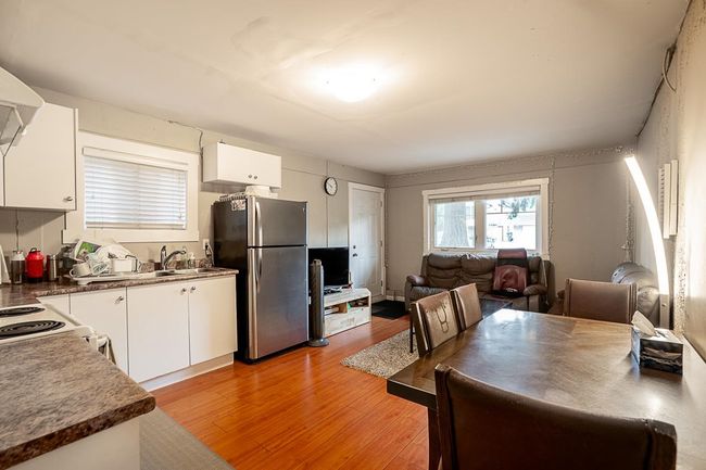 Kitchen with freestanding refrigerator, white cabinetry, light wood-style flooring, and open floor plan | Image 23