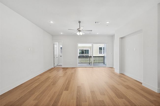 Unfurnished living room with light wood-type flooring and ceiling fan | Image 9