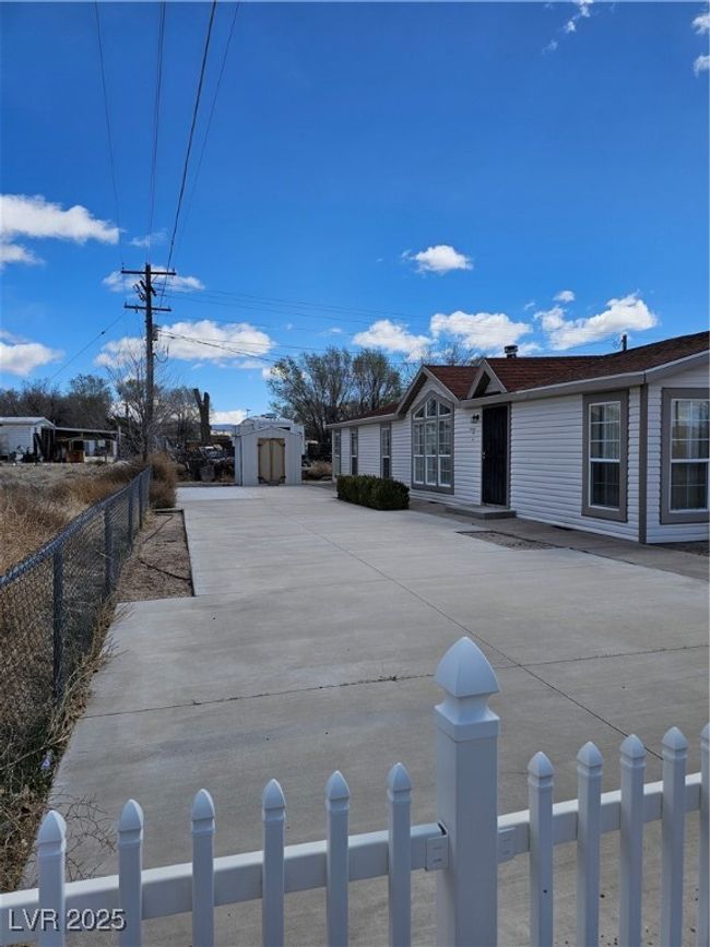 View of front of house featuring an outdoor structure, a shed, and fence | Image 4