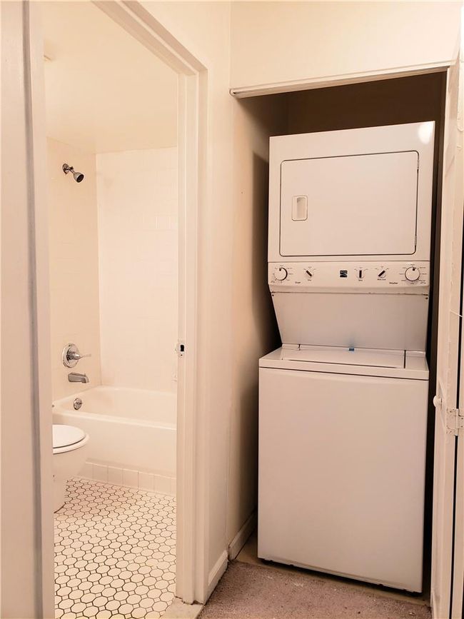 Washroom featuring stacked washer / drying machine | Image 12