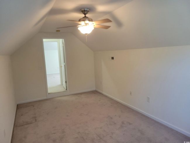 Additional living space with a ceiling fan, vaulted ceiling, and light colored carpet | Image 33