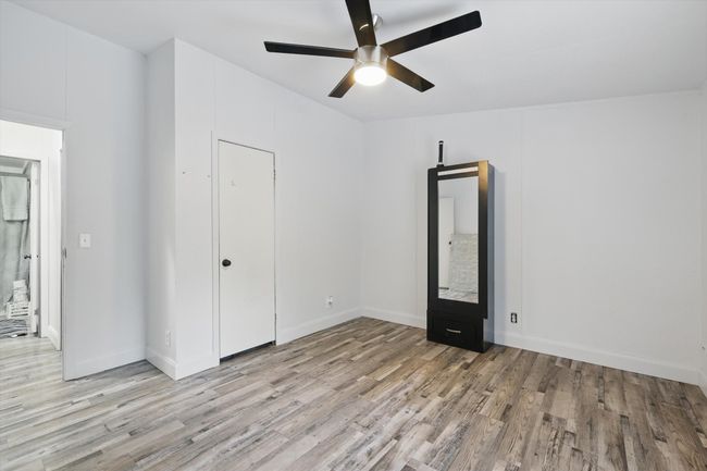 Unfurnished bedroom with a ceiling fan, baseboards, and light wood-style floors | Image 17