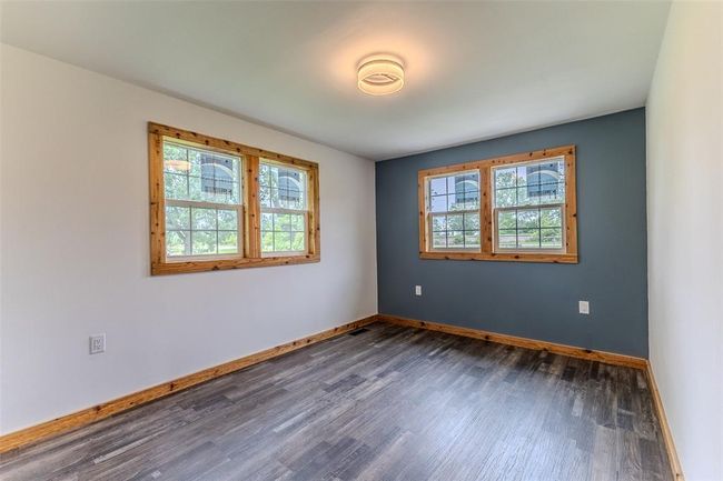 Unfurnished room featuring plenty of natural light, dark wood-style flooring, and baseboards | Image 34