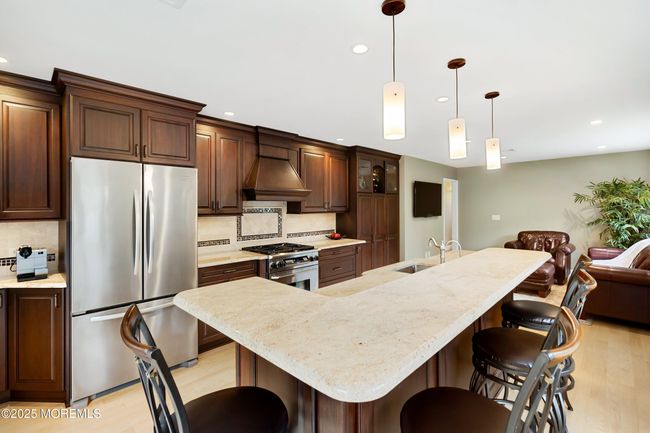 Kitchen island has sink with water filter, instant hot water and garbage disposal | Image 17