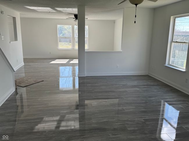 unfurnished living room with baseboards and ceiling fans | Image 4