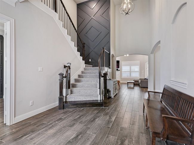 Striking stairwell with designer accent wall leading to second floor. | Image 4