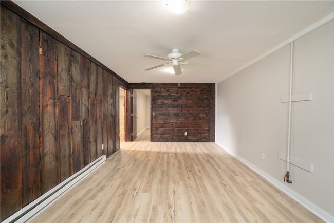 Unfurnished room with a baseboard radiator, ceiling fan, wood finished floors, and baseboards | Image 21