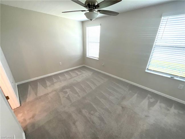 Carpeted spare room featuring baseboards and a ceiling fan | Image 9