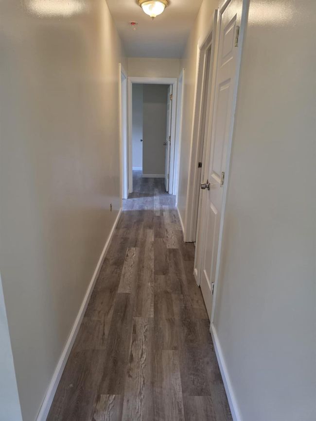 Hallway with baseboards and dark wood-style floors | Image 16