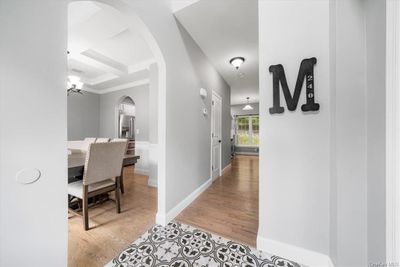 Hallway with coffered ceiling, ornamental molding, beamed ceiling, and light hardwood / wood-style flooring | Image 3