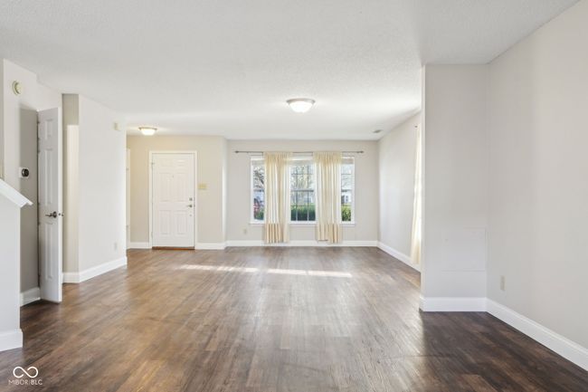 unfurnished living room featuring dark wood finished floors and baseboards | Image 18