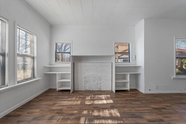 Unfurnished living room with a fireplace and dark hardwood / wood-style flooring | Image 9