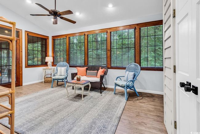 Living area featuring ceiling fan, plenty of natural light, wood finished floors, lofted ceiling, and recessed lighting | Image 12