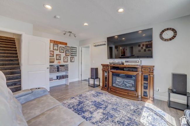 Living area with recessed lighting, wood finished floors, and stairs | Image 9