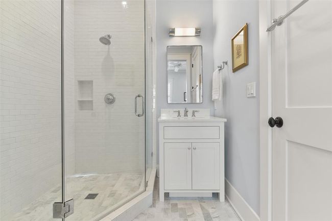 Charming guest bathroom with a marble floors and walk-in shower. | Image 22