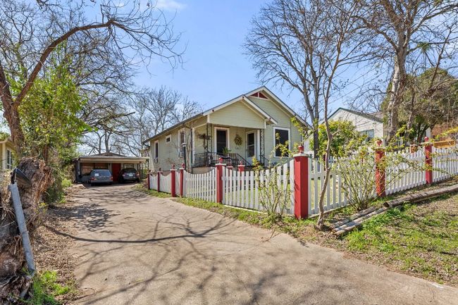 Bungalow-style house featuring a carport, driveway, and a fenced front yard | Image 29