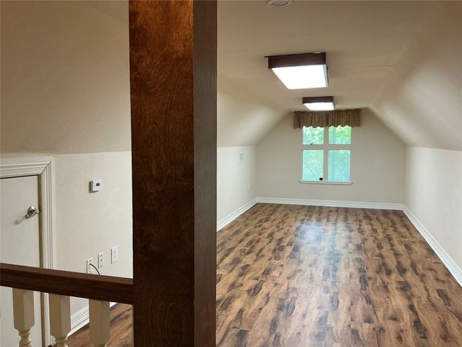 Additional living space featuring baseboards, vaulted ceiling, and wood finished floors | Image 20